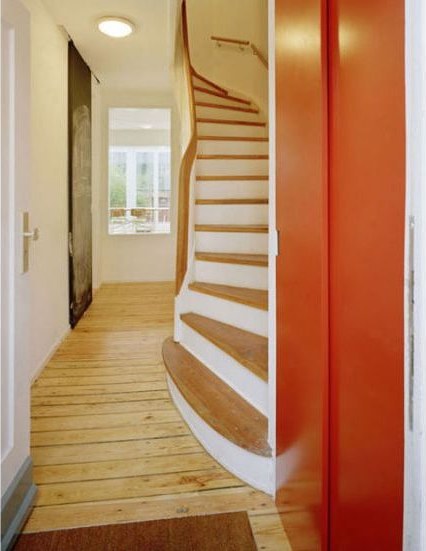 Wendeltreppe mit rot gefasster Wand im Reihenhaus
